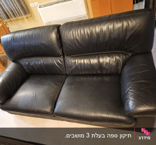 ספת עור שחורה ומרופדת בסלון הבית
